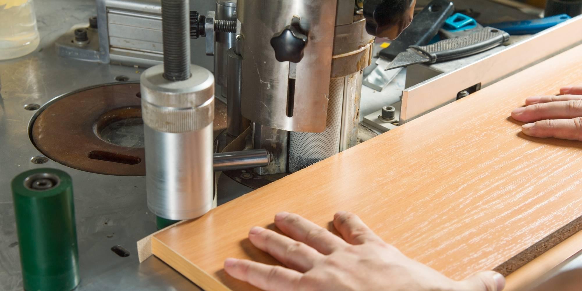 Woodworker edge banding a wooden plank